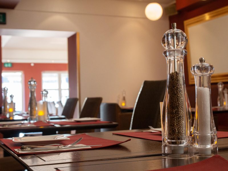 Stimmungsvolle Bar im Steakhaus La Plaza II mit warmem Licht und Weinauswahl