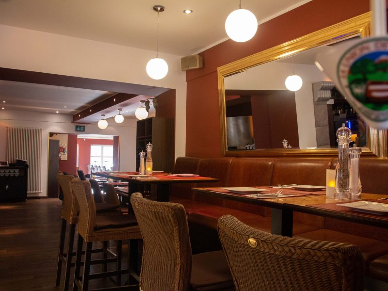 Überdachte Terrasse mit gedeckten Tischen im Steakhaus La Plaza II