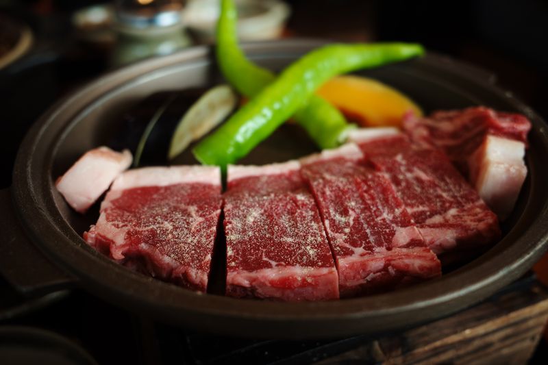 Marmoriertes Wagyu-Rindfleisch brutzelt auf heißem Stein